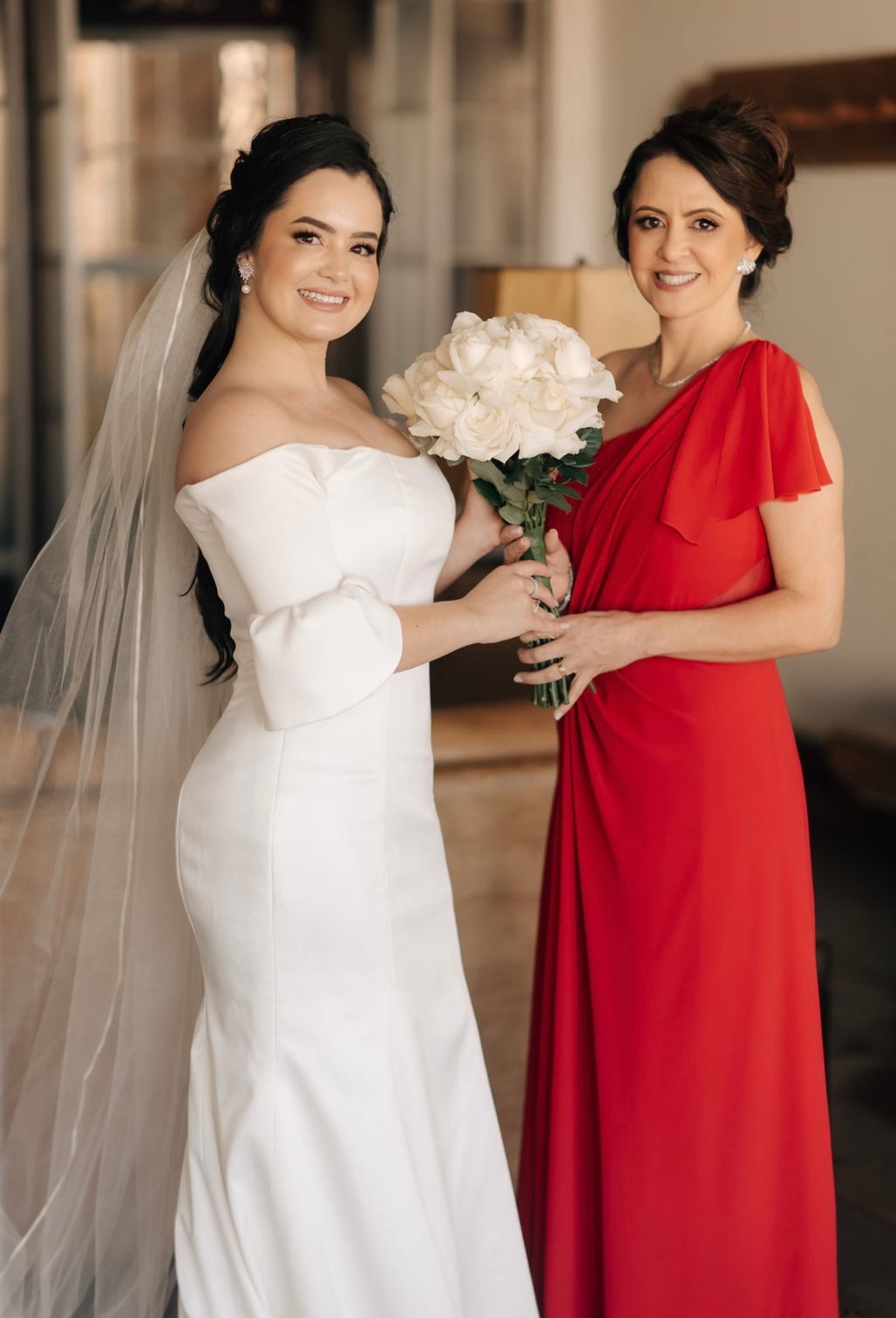 Noiva ao lado da madrinha de vestido vermelho