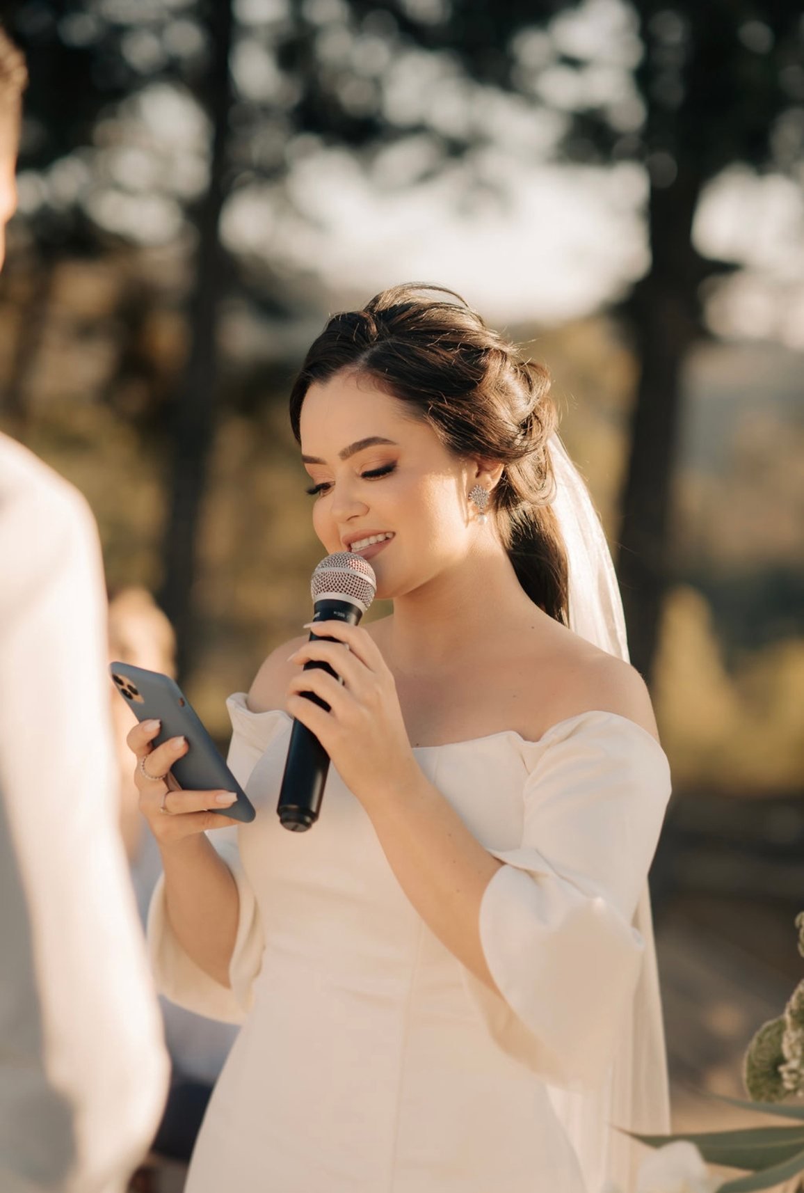 Noiva sorrindo e cantando com microfone